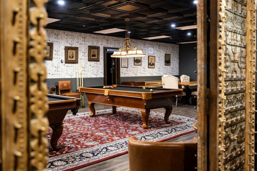 Warm shared team lounge with tables and seating